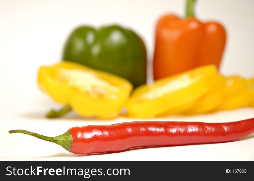 Green, yellow,orange and red paprika on a white background. Green, yellow,orange and red paprika on a white background.