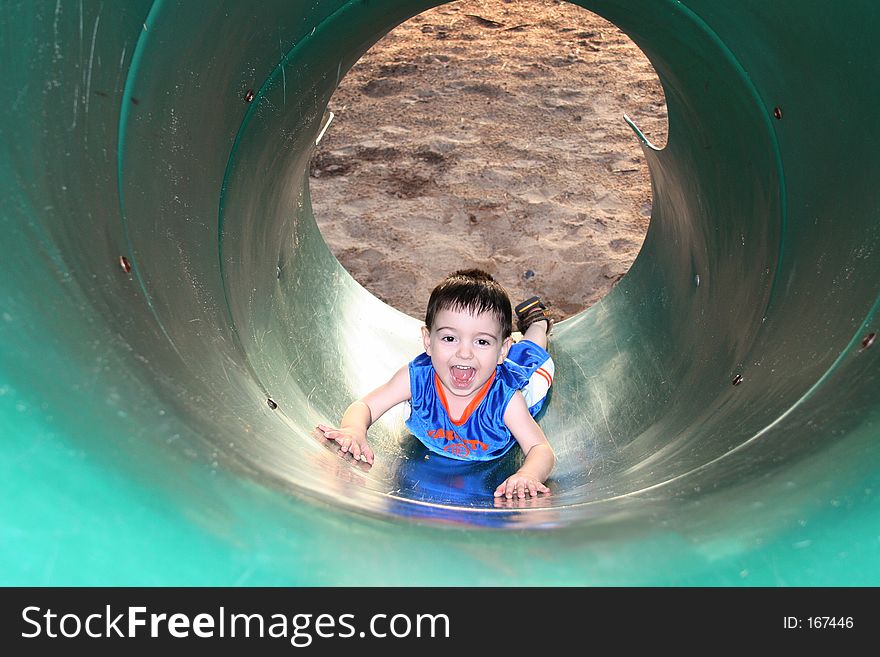 Boy Laughing And Playing With The Slide