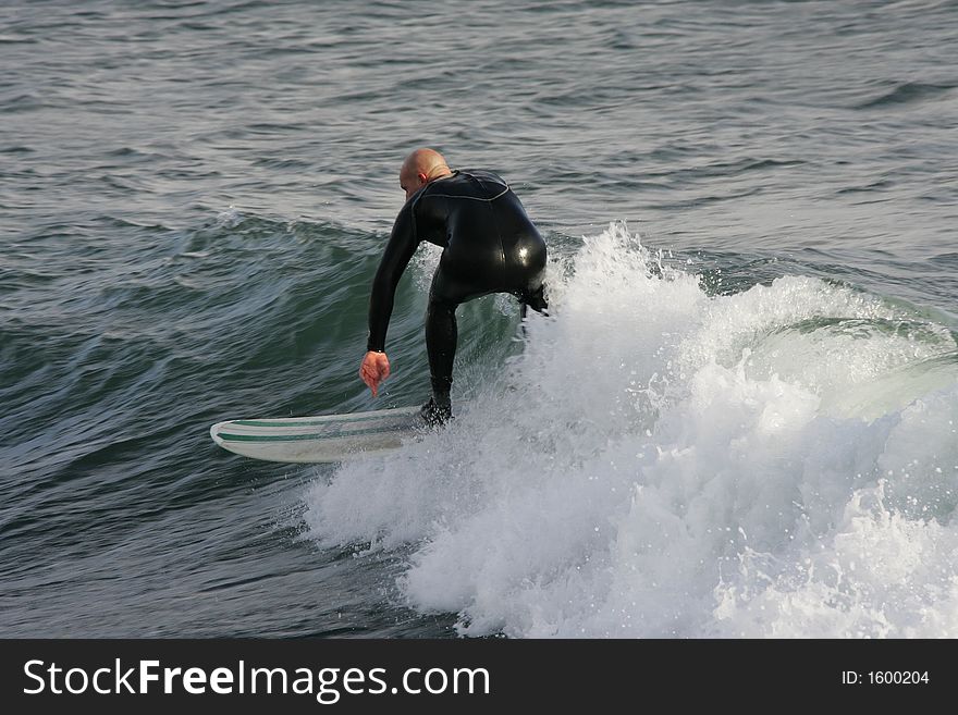 Surfer surfing in a low wave. Surfer surfing in a low wave