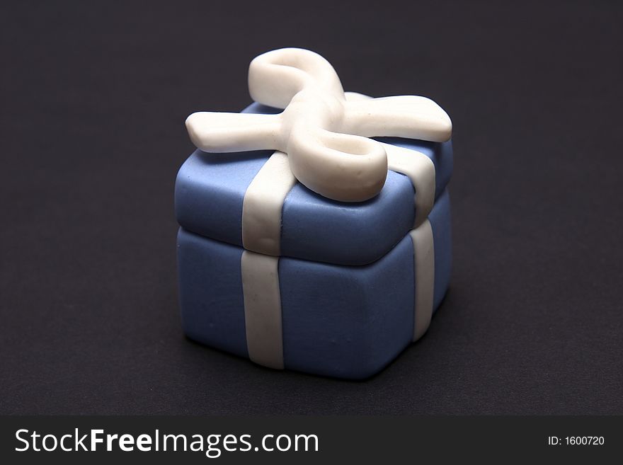 Blue Porcelain Gift Box with White Ribbon against black background