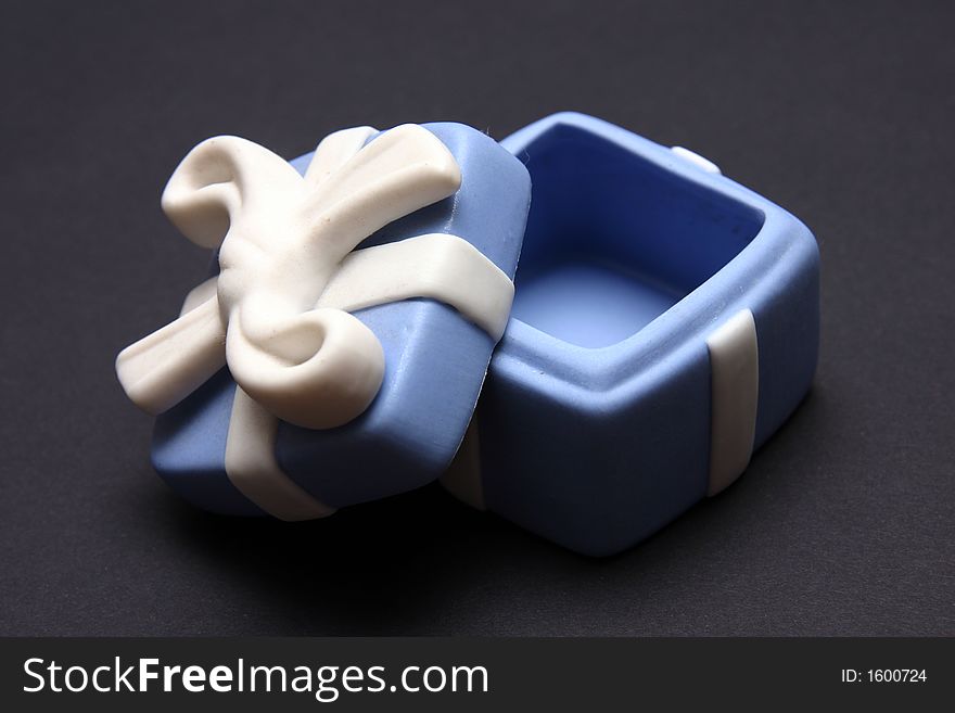 Blue Porcelain Gift Box with White Ribbon against black background