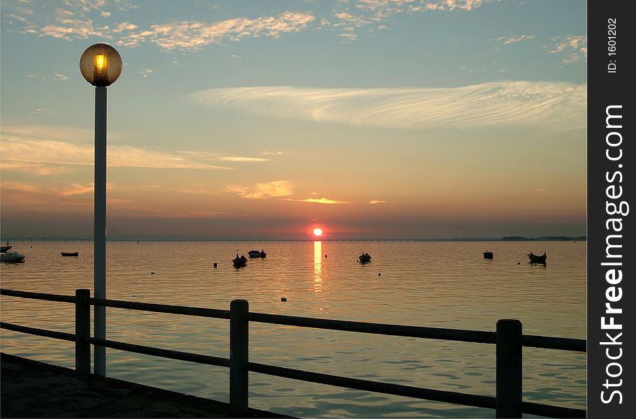 Old pier with lamp and boats