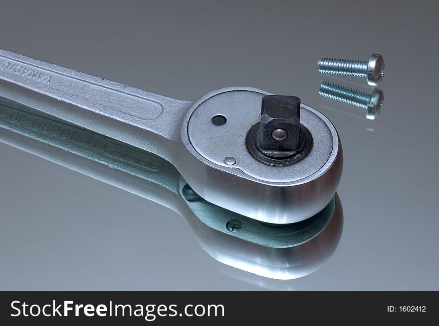 Wrench and a screw on a reflecting surface. Wrench and a screw on a reflecting surface
