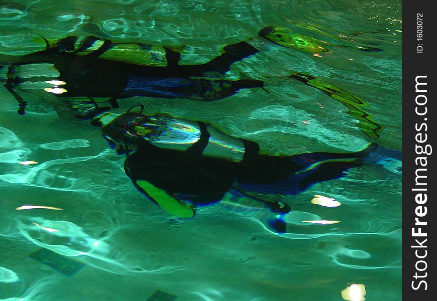 Scuba instructor and junior student learning scuba in a pool. Scuba instructor and junior student learning scuba in a pool