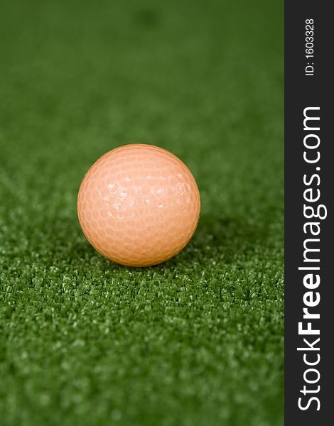 Picture of orange golf ball on practice tee