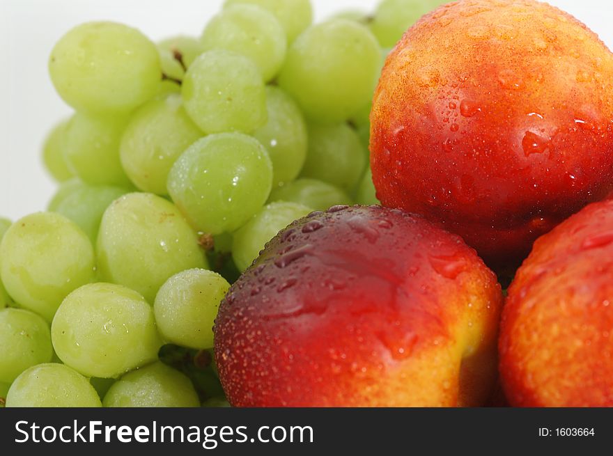 Colorful nectarines (peaches) and green grapes. Closeup. Colorful nectarines (peaches) and green grapes. Closeup.