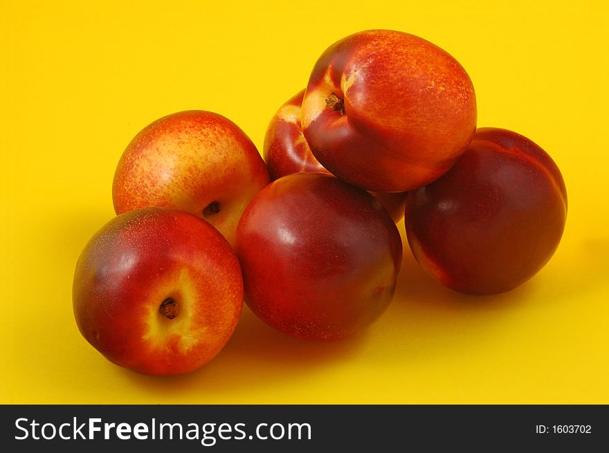 Colorful nectarines (peaches) over yellow background. Colorful nectarines (peaches) over yellow background.