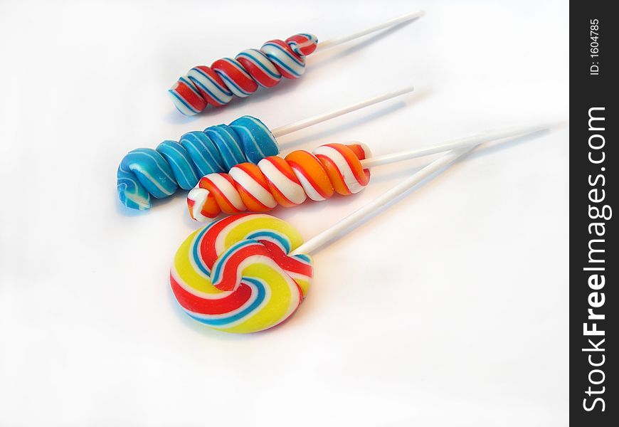 Multi-coloured a sugar candy on a stick on a white background