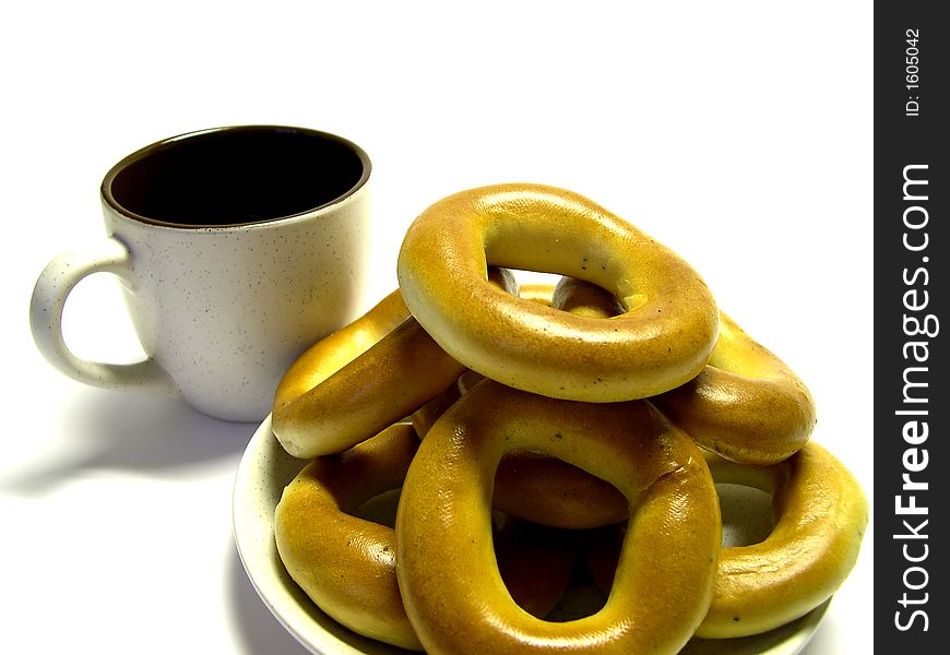 Pretzel in a plate and a mug on a white background. Pretzel in a plate and a mug on a white background