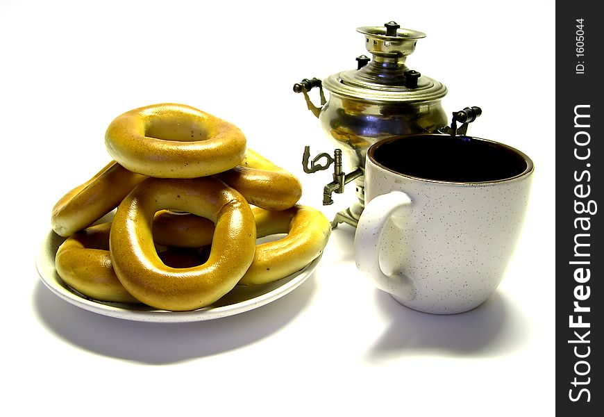 Pretzel in a plate, a samovar and a mug on a white background. Pretzel in a plate, a samovar and a mug on a white background