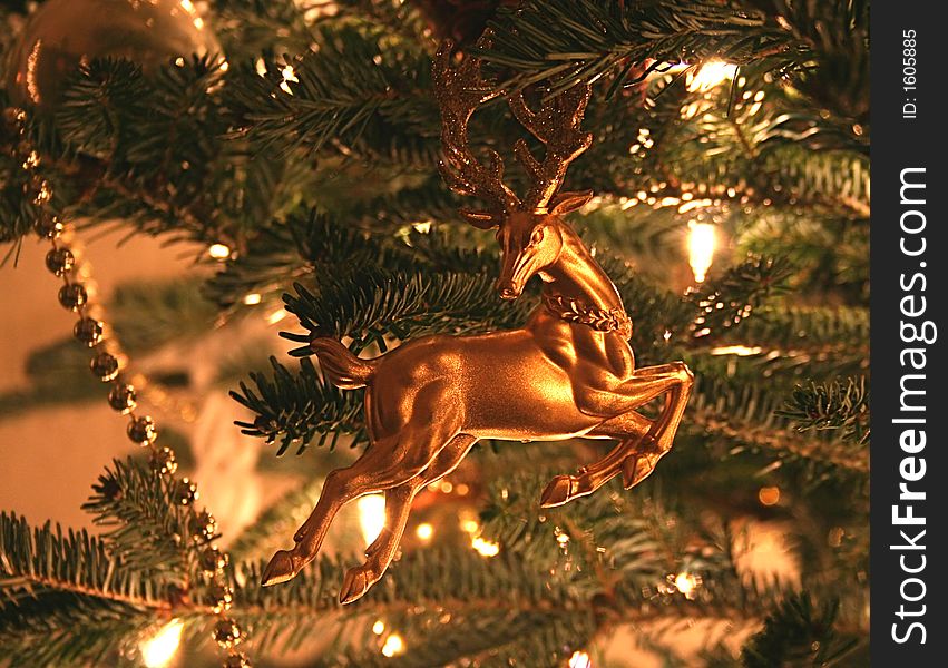 Gold reindeer Christmas ornament surrounded by soft glowing lights. Gold reindeer Christmas ornament surrounded by soft glowing lights.