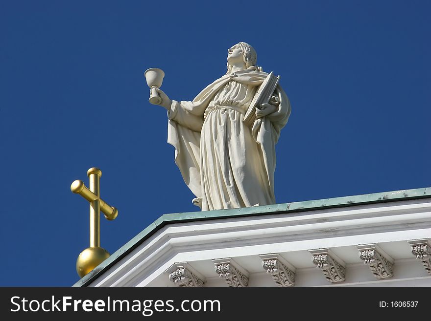 A White marble statue holding a chalice cup. A White marble statue holding a chalice cup