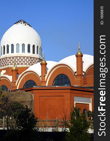 Beautiful white domed building with birds perched on top against bright blue sky. Beautiful white domed building with birds perched on top against bright blue sky