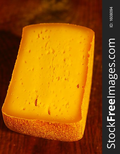 Swiss cheese block on wooden desk