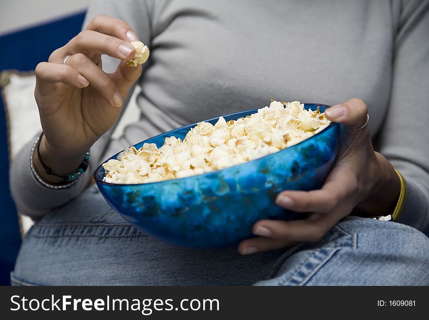 Girl eating popcorns while watching tv at home. Girl eating popcorns while watching tv at home