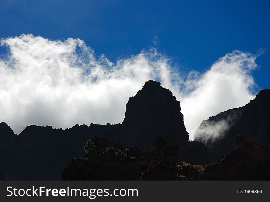 Stormclouds moving over the ridge of the caldera in Tenerife, Canary Islands. Back-lighting. Stormclouds moving over the ridge of the caldera in Tenerife, Canary Islands. Back-lighting.