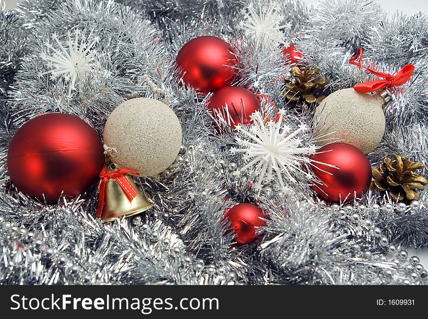 Red and silver globes on tinsel background with snowflakes pine cones christmas decorations