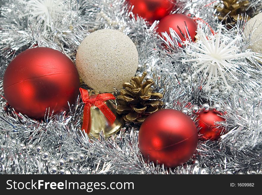 Red and silver globes on tinsel background with snowflakes pine cones christmas decorations