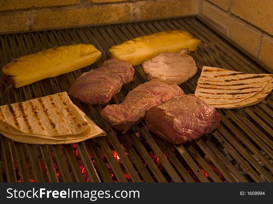 Appetizing pieces of pork and beef meat with pines roasting on grid. Appetizing pieces of pork and beef meat with pines roasting on grid