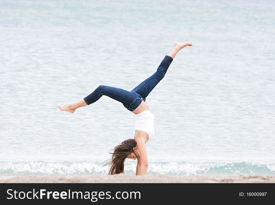 Young girl doing gymnastics on sea background