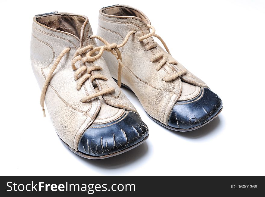 Black and white colored baby shoes out of the 60s on white background