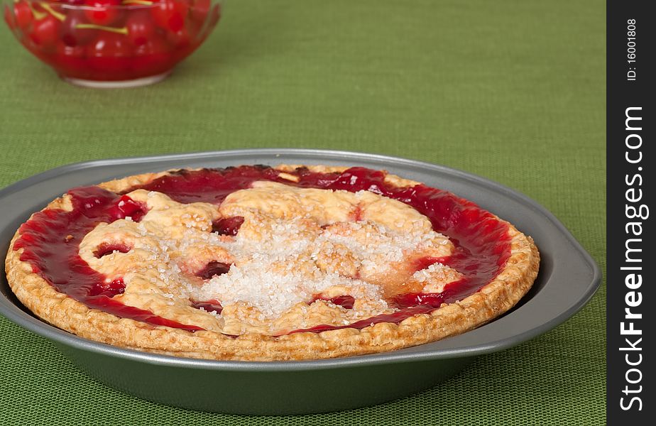 Cherry fruit pie with bowl of cherries in background. Cherry fruit pie with bowl of cherries in background