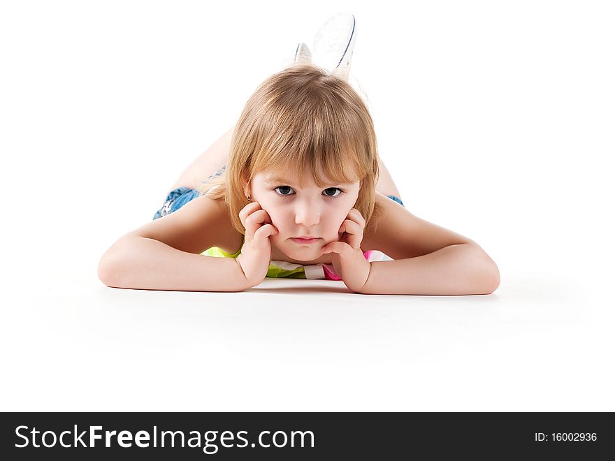 Cute little girl lie on the floor. Studio shot