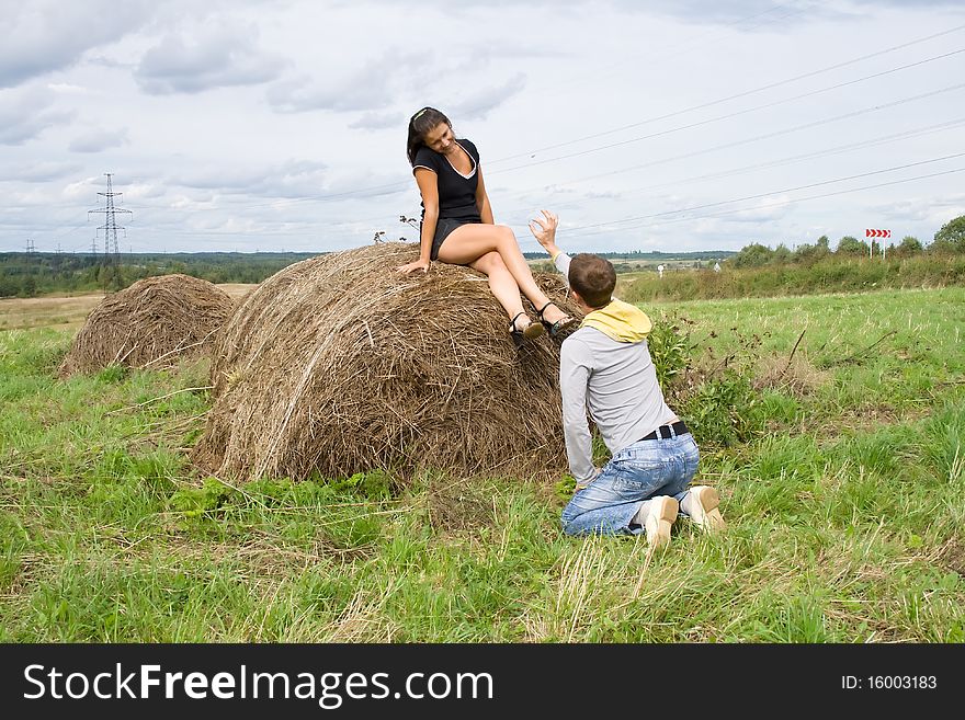 Young couple costs about a haystack