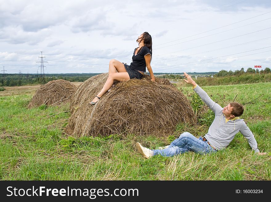 Young couple costs about a haystack