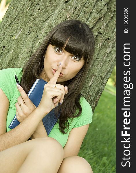 Young beautiful woman in a park with a notebook. Young beautiful woman in a park with a notebook