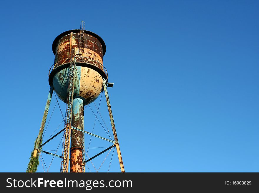 Old Rusty Watertower Against Blue Sky