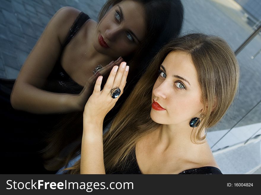 Portrait of elegantly beautiful young woman. The girl beautiful jewelry, ring and earrings with large blue stones. Portrait of elegantly beautiful young woman. The girl beautiful jewelry, ring and earrings with large blue stones