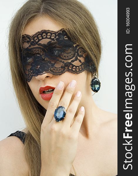 Beautiful fashionable girl on the ring finger is clothed with a large blue gemstone. Blindfolded black lace ribbon. Beautiful fashionable girl on the ring finger is clothed with a large blue gemstone. Blindfolded black lace ribbon