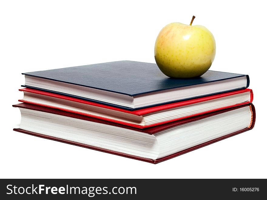 Stack of books and green apple on a white background