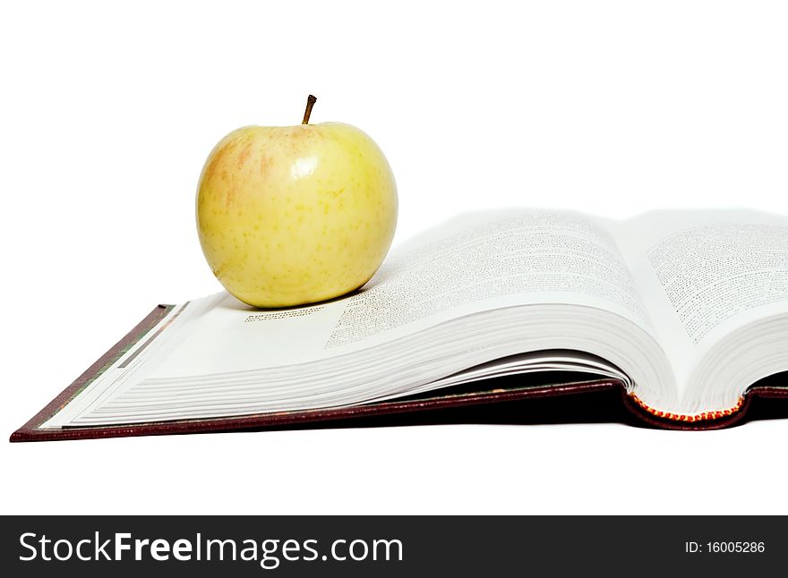 Open book and green apple on a white background