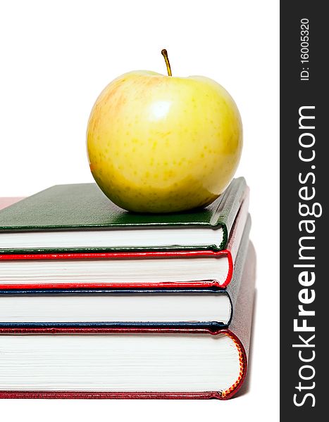 Stack of books and green apple on a white background