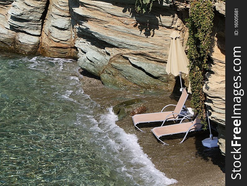 Wo beach beds under umbrella on a private beach in crete. Wo beach beds under umbrella on a private beach in crete