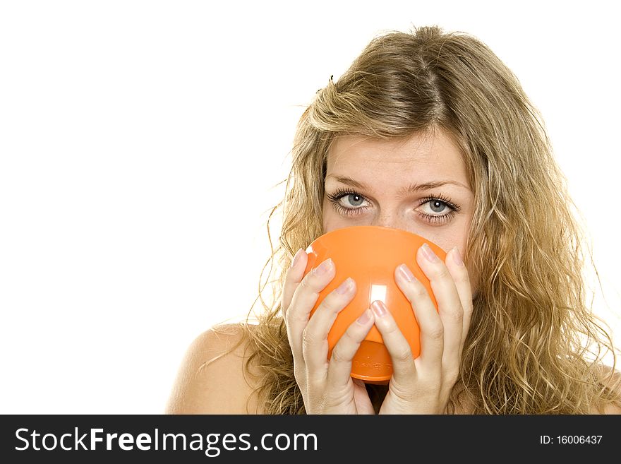 Pretty young woman drinking from a cup of orange of coffee / tea. Isolated on white background. Pretty young woman drinking from a cup of orange of coffee / tea. Isolated on white background