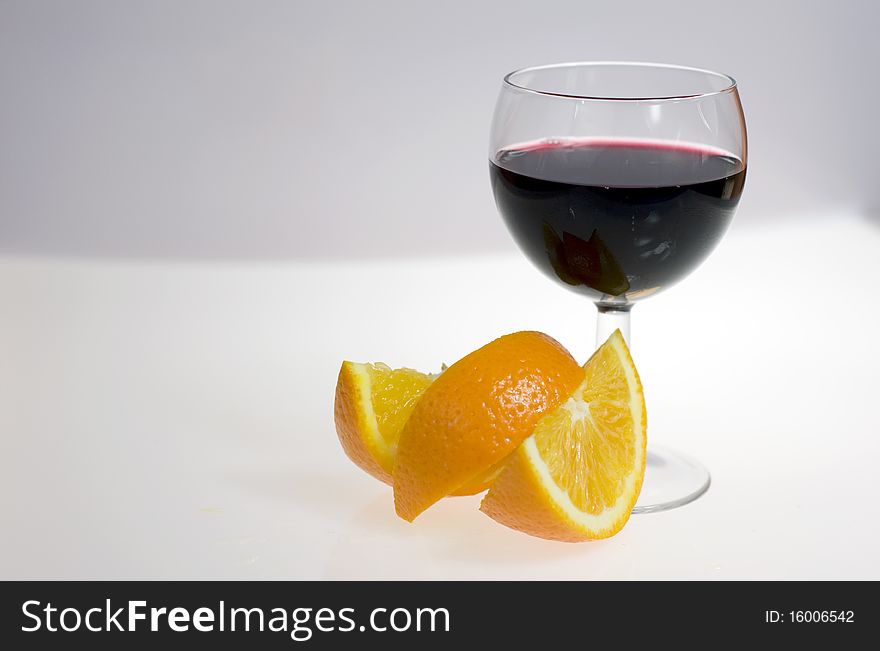 Wine glass with orange on background