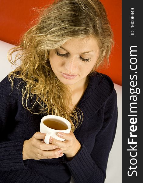 Young woman drinking tea while sitting on the couch. Young woman drinking tea while sitting on the couch