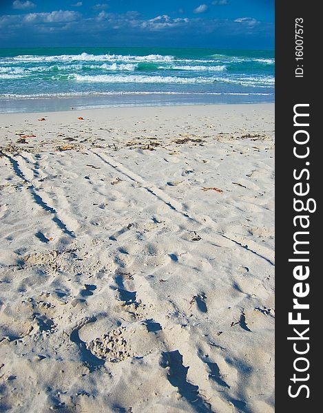 White sand beach now deserted with turquoise blue sea and blue sky in the background