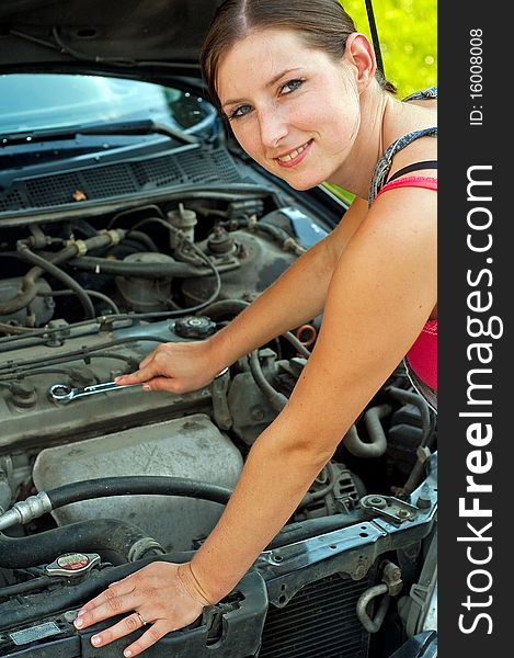 Young woman repairing her car. Young woman repairing her car