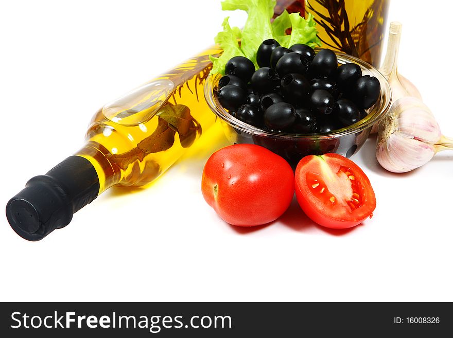 A bottle of olive oil with pasta and black olives isolated on a white background.