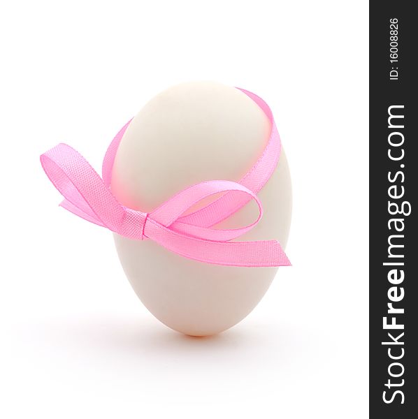 White egg wrapped around with pink ribbon over white background. White egg wrapped around with pink ribbon over white background