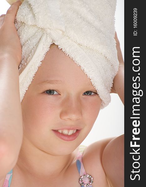 Young girl smiling and looking into the camera with a towel wrapped around her wet hair. Young girl smiling and looking into the camera with a towel wrapped around her wet hair