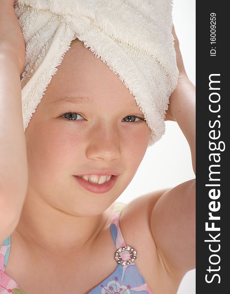 Young girl smiling and looking into the camera with a towel wrapped around her wet hair. Young girl smiling and looking into the camera with a towel wrapped around her wet hair