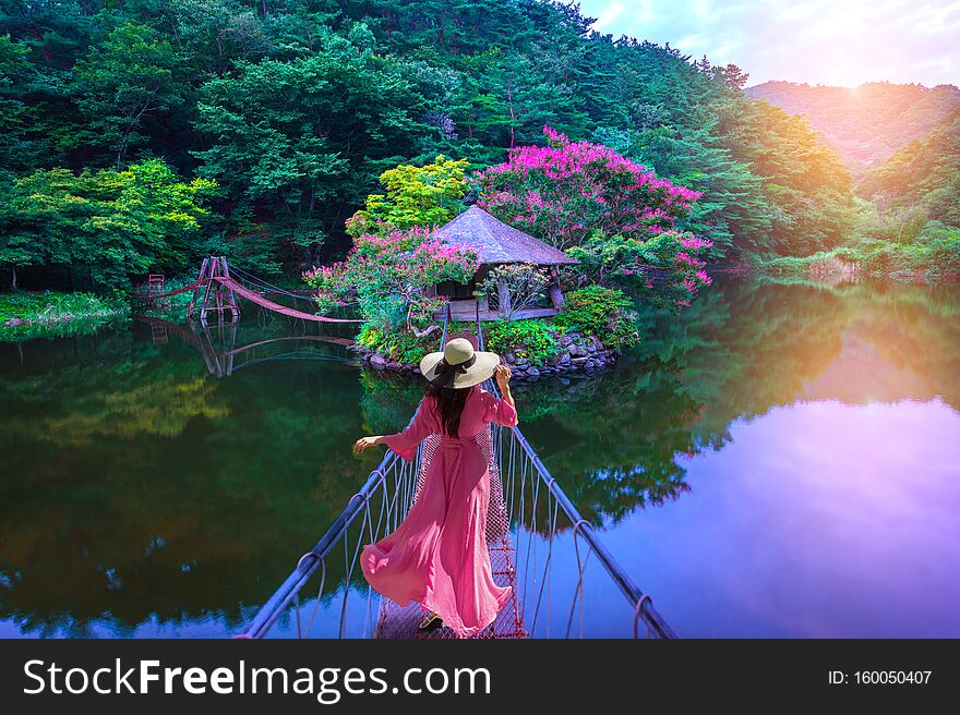 Asian Woman Walks On A Red Bridge To An Island Resort In Suncheon, South Korea