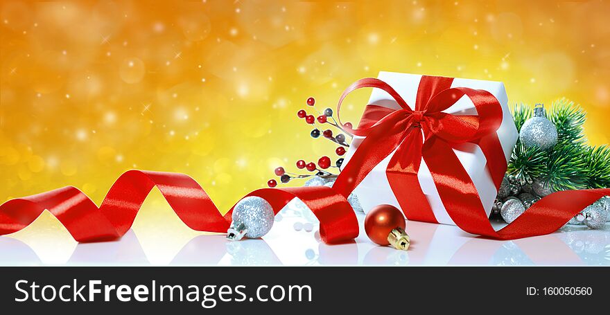 Christmas gift with decoration on yellow bokeh background. Holiday greeting card