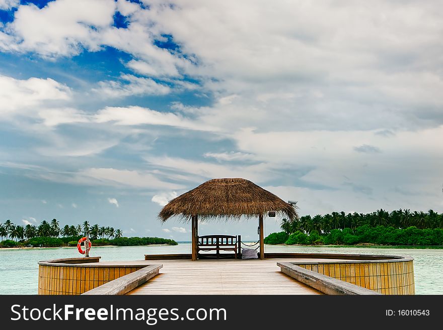 Wooden jetty leading to bungalow among turquoise ocean waters