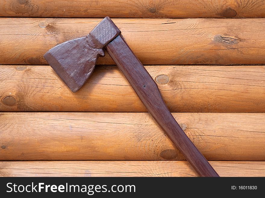 A fragment of wood veneer wall with an attached ax. Texture, background. A fragment of wood veneer wall with an attached ax. Texture, background